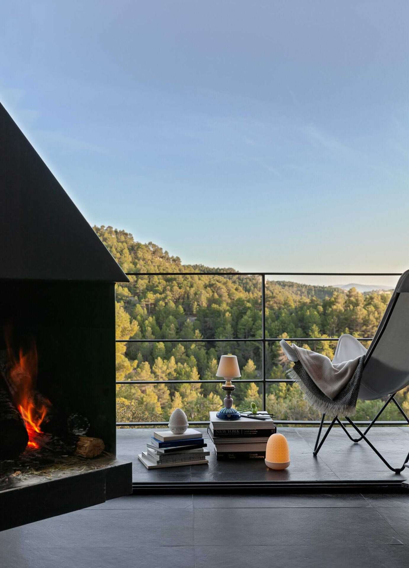 Lladró Sunflower Firefly lamp on a balcony overlooking pine forest at dusk